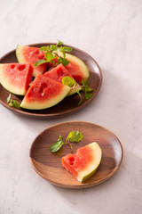 Cut slices of ripe juicy watermelon on wood plate