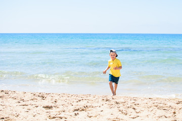 The little boy running near the sea.