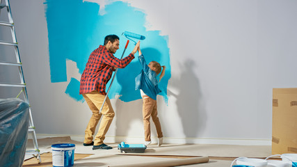 Young Father is Showing How to Paint Walls to Cute Small Daughter. They Give High Give to Each...
