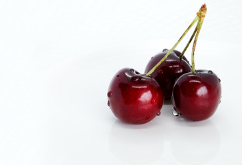 Bunch of sweet cherries on a white plate
