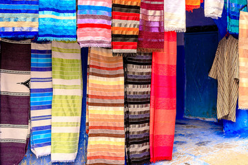 Colorful Moroccan fabrics and handmade souvenirs on the street in the blue city Chefchaouen, Morocco, Africa..