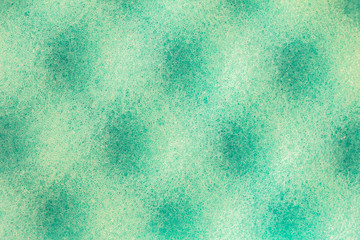 Light green emerald background with a spotty pattern of round shadows. The porous surface of the material under high magnification. Nano and microstructure of a porous sponge under a microscope.
