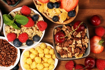 Cereal. Bowls of various cereals, berries and milk for breakfast. Muesli with kids cereals.