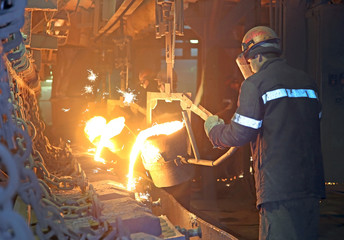 Workers  pours hot metal into the mold.
