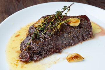 Rib-eye steak resting on a white plate