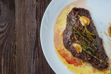 Rib-eye steak resting on a white plate