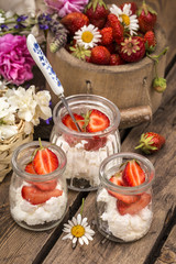 strawberry with cream cheese in glass jars, healthy summer food in a rustic style