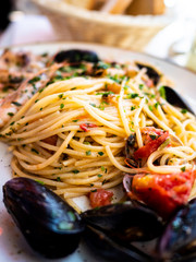 Spaghetti allo scoglio or spaghetti with seafood served in a white dish with shrimps