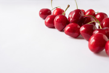 Obraz na płótnie Canvas Cherries on a white background. Fresh red cherries. Texture blueberry berries close up. Cherry fruit. Cherries with copy space for text. Top view. Background of cherries.