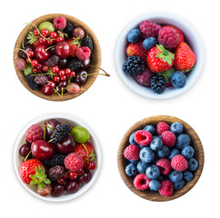 Top view. Fruits and berries in bowl isolated on white background. Ripe raspberries, blueberries, cherries, strawberries, blackberries, mulberries and gooseberries. 