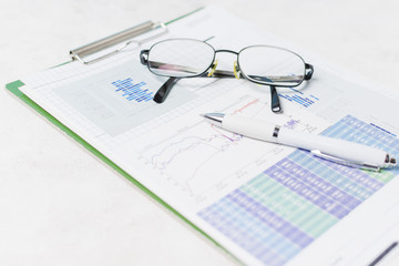 Glasses and pen on report