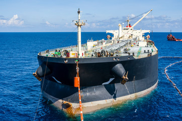 Oil tanker is transferring supply to the oil vessel.