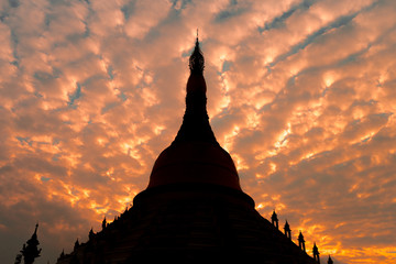 Buddhism Pagoda silhouette with beautiful orange twilight couldy sky. The importance landmark of Thailand and Myanmar historic culture.