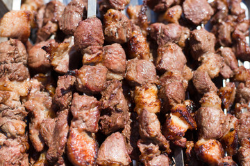 The texture of roasted meat. Appetizing cuts of meat on skewers. Grilled lamb, very tasty food. Kebab background.