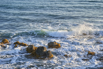 Ocean coast with rocks and waves at sunrise. Beautiful seascape