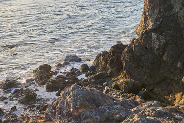Ocean coast with rocks and waves at sunrise. Beautiful seascape