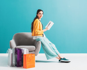 Woman shopping and reading a fashion magazine