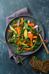 Vegan salad with baked carrot, avocado, nuts