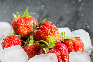 Strawberries and ice on grey background
