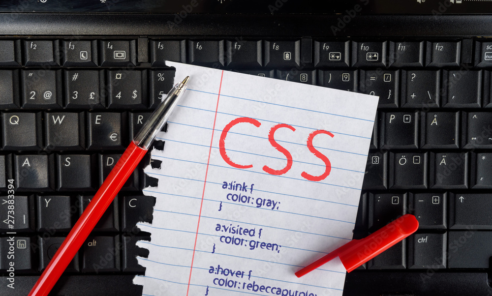 Poster CSS. Paper width css code and pencil on laptop keyboard