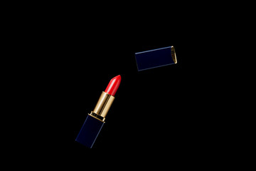 top view of opened tube of red lipstick isolated on black