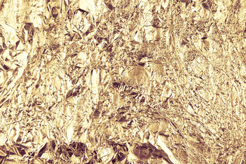 Abstract crumpled foil background. Grunge photo background. Gold colors