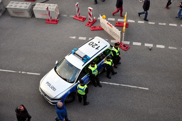 Veranstaltungssicherheit : Polizisten im Einsatz bei einem Stadtfest. Eine Stra&szlig;ensperre gesichert durch Polizisten und ein Polizeiauto, bei einer Gro&szlig;veranstaltung aus der Vogelperspektive.