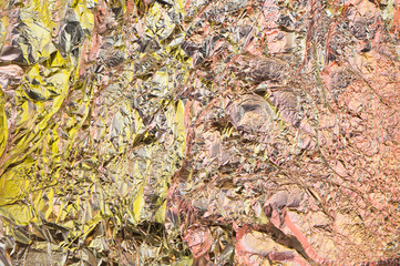 Abstract crumpled foil background. Grunge photo background. Yellow and orange shadows