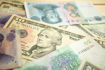 Select focus of 10 US dollar stack under China yuan banknote. Concept of Trade war between the United States and China.