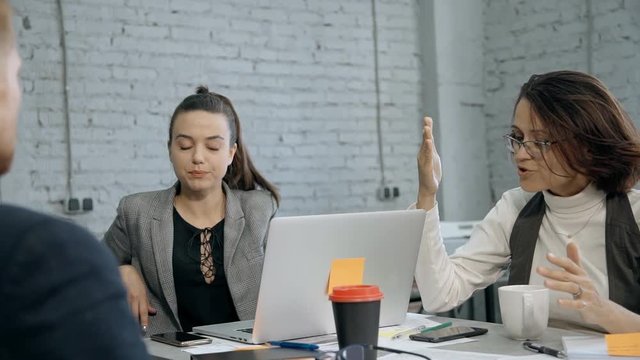 Businesswoman making conversation with employee in modern office