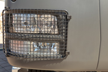 Linzed truck headlamp protected by a metal grill