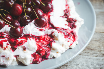 Cherry dessert with whipped cream and meringue cream. Selective focus. Shallow depth of field.