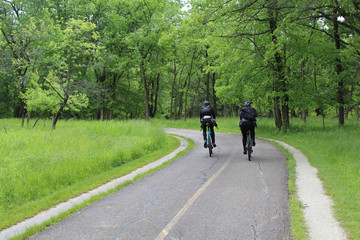 Obraz premium Man and woman on bikes on the North Branch Trail at Miami Woods in Morton Grove