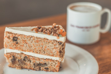 Classic American Carrot Cake with cream cheese frosting and a cup of hot latte
