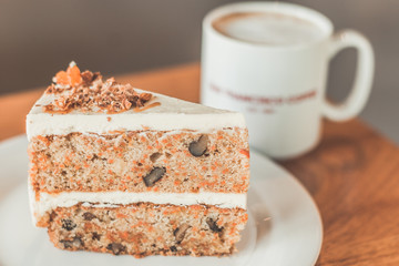 Classic American Carrot Cake with cream cheese frosting and a cup of hot latte