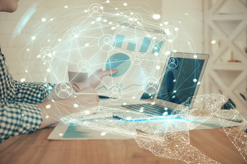Social network theme hologram with businessman working on computer on background. Concept of world...