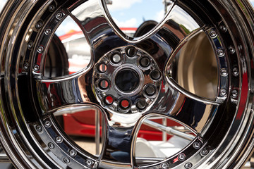 Modern metal alloy wheel for cars. Showcase with rims. Closeup view.