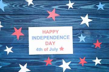 Text Happy Independence Day 4th of July with paper stars on blue wooden table
