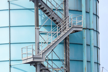 Stairs leading to the sky on a white industrial tank