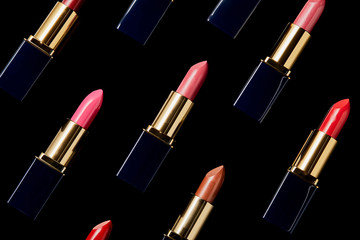 background with various shades of lipsticks isolated on black