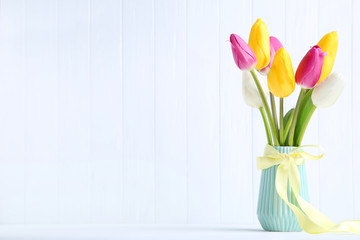Bouquet of tulip flowers in vase on white background
