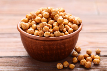 Roasted chickpeas in bowl on wooden table