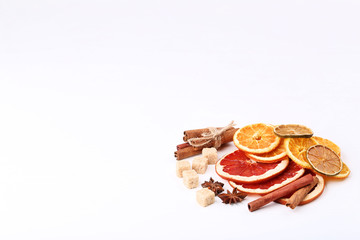 Dried citrus fruits with cinnamon, star anise and sugar cubes on white background