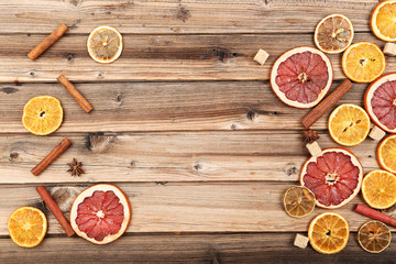 Dried citrus fruits with cinnamon, star anise and sugar cubes on brown wooden table