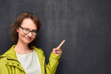 Portrait woman pointing with index finger at top right