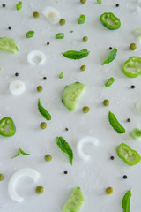 Composition of fresh green vegetables and herbs on white background. Vegetable salad ingredients. Creative food pattern. Flat lay