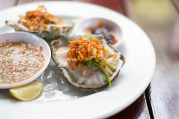 Fresh Oyster Thai style with spicy sauce serve with Chili paste, crispy shallots, garlic and fresh vegetable.