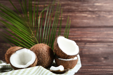 Ripe coconuts with palm leafs on wooden table