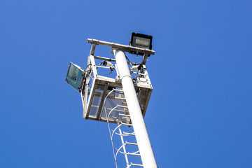 Spot light pole over clear blue sky background