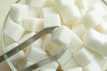 pieces of crystal sugar with sugar tongs. concept - sugar for tea